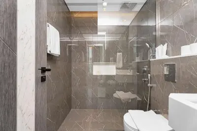 a bathroom with a shower with a toilet and a sink at Luxury 1BR with Private Pool & Balcony in Dubai