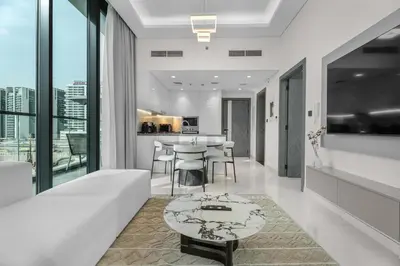 a living room with a white couch and a table at Luxury 1BR with Private Pool & Balcony in Dubai