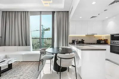 a kitchen and living room with a table and chairs at Luxury 1BR with Private Pool & Balcony in Dubai