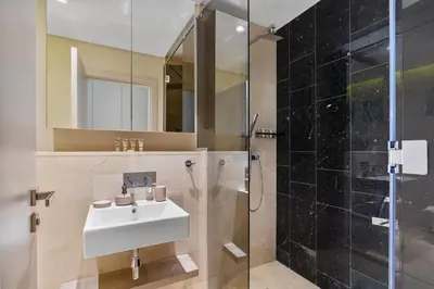 a bathroom with a sink and a shower at Stunning 2 Bedroom in Palm with private beach in Dubai