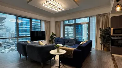 a living room with blue furniture and large windows at 3BDR Duplex Apartment with Large Family Living Room in Dubai