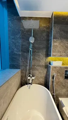 a white bath tub in a bathroom with a blue wall at 3BDR Duplex Apartment with Large Family Living Room in Dubai