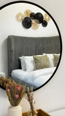 a mirror hanging on a wall above a bed at 3BDR Duplex Apartment with Large Family Living Room in Dubai