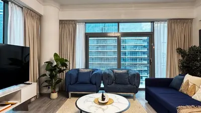 a living room with a blue couch and two chairs at 3BDR Duplex Apartment with Large Family Living Room in Dubai