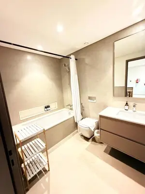 a bathroom with a tub and a sink and a toilet at Oshima Grande Downtown 1BR Burj Khalifa in Dubai