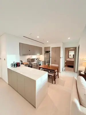 a kitchen and living room with a couch and a table at Oshima Grande Downtown 1BR Burj Khalifa in Dubai