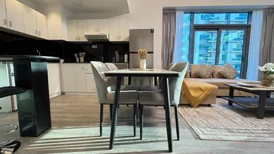 a living room with a table and chairs and a couch at 1 Bedroom centrally located with large balcony in Dubai