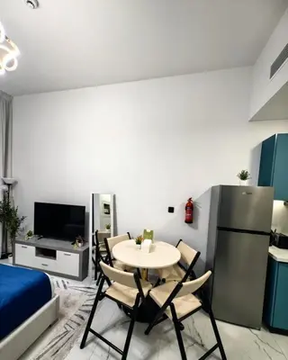 a kitchen with a table and chairs in a room at Modern Studio in Opalz - Ideal for Work & Leisure in Dubai