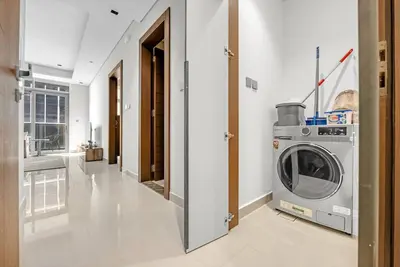 a laundry room with a washing machine in it at Nobles Tower- Luxe with Skies-High 1BR Lifestyle in Dubai