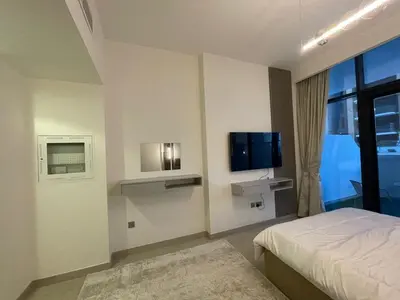 a bedroom with a bed and a tv on the wall at Quiet Studio in Azizi 18-Ideal for Work & Leisure in Dubai