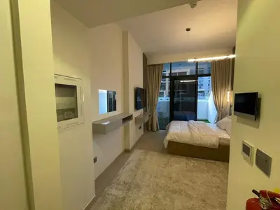 a hotel room with a bed and a television at Quiet Studio in Azizi 18-Ideal for Work & Leisure in Dubai