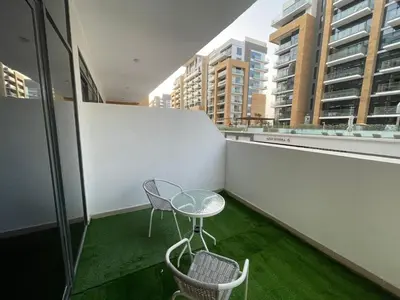 a patio with a table and chairs on a balcony at Quiet Studio in Azizi 18-Ideal for Work & Leisure in Dubai