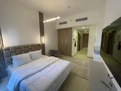a bedroom with a large white bed and a sink at Quiet Studio in Azizi 18-Ideal for Work & Leisure in Dubai