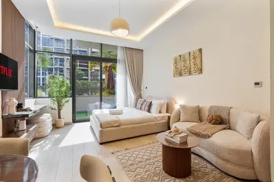 a living room with a couch and a table at Chic Studio at Azizi Riviera Near Downtown Dubai in Dubai