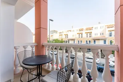 a balcony with a table and chairs and a street at HAVN - Studio in Botanica, JVC in Dubai