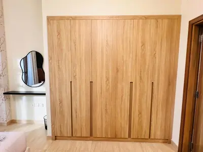 a large wooden cabinet in a room with at Celestial 2BR with Burj Khalifa View in Dubai