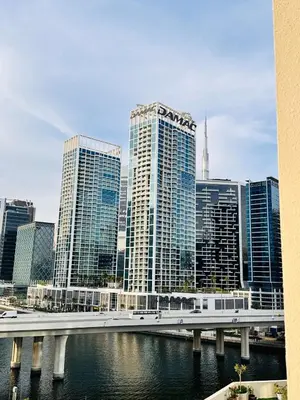 a bridge over a river in a city with tall buildings at Celestial 2BR with Burj Khalifa View in Dubai