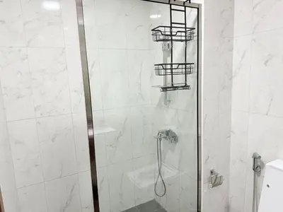 a bathroom with a shower with a glass door at An elegant sanctuary in Dubai