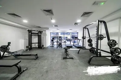 a gym with several treadmills and machines in a room at An elegant sanctuary in Dubai