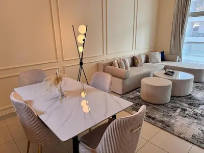 a living room with a white table and chairs at Skylux Bright 1BR with Canal Views & Extra Bed in Dubai