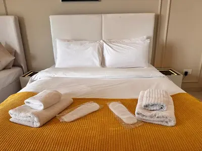a bed with two towels and two slippers on it at Skylux Bright 1BR with Canal Views & Extra Bed in Dubai