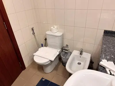 a bathroom with a white toilet and a sink at Skylux Bright 1BR with Canal Views & Extra Bed in Dubai