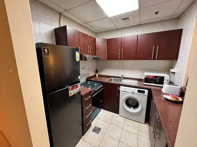 a kitchen with a black refrigerator and a dishwasher at Skylux Bright 1BR with Canal Views & Extra Bed in Dubai