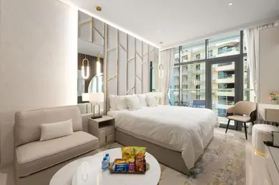 a bedroom with a bed and a couch and a chair at Splendid studio on the Palm, infinity pool & private beach in Dubai
