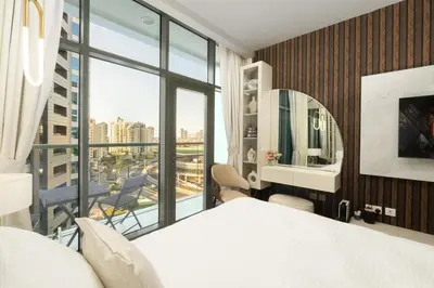 a bedroom with a white bed and a large window at Splendid studio on the Palm, infinity pool & private beach in Dubai