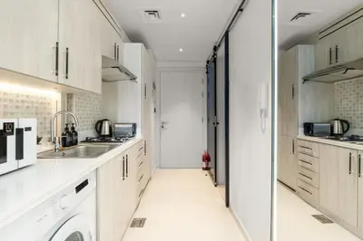 a kitchen with white cabinets and a sink at Splendid studio on the Palm, infinity pool & private beach in Dubai