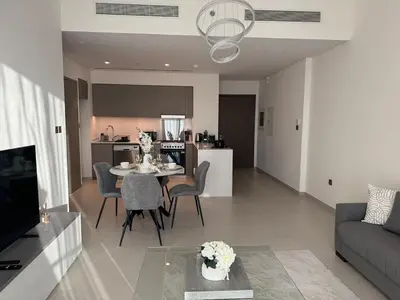 a living room and kitchen with a table and chairs at Harmonizing apartment 1BR with a balcony in Grande in Dubai
