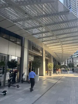 a man walking in front of a building at Harmonizing apartment 1BR with a balcony in Grande in Dubai