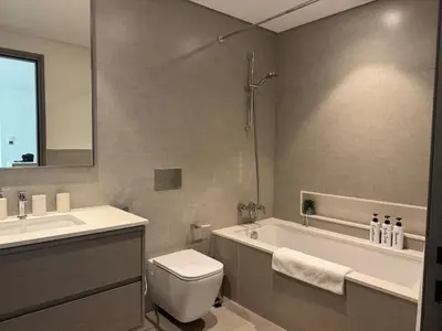 a bathroom with a tub and a toilet and a sink at Harmonizing apartment 1BR with a balcony in Grande in Dubai