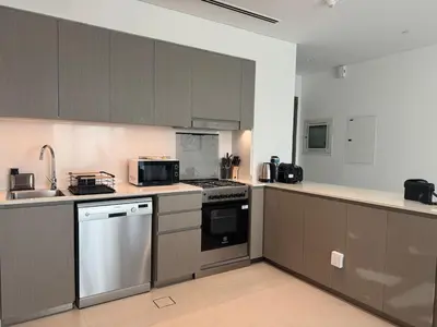 a kitchen with stainless steel appliances and brown cabinets at Harmonizing apartment 1BR with a balcony in Grande in Dubai