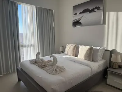 a bedroom with a bed with swans towels on it at Harmonizing apartment 1BR with a balcony in Grande in Dubai