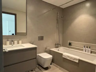 a bathroom with a tub and a toilet and a sink at Harmonizing apartment 1BR with a balcony in Grande in Dubai