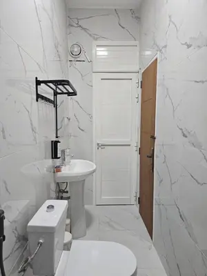 a white bathroom with a toilet and a sink at Green Zen Studio Metro 15 mins walk away in Dubai