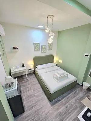 a bedroom with a large bed and a table at Green Zen Studio Metro 15 mins walk away in Dubai