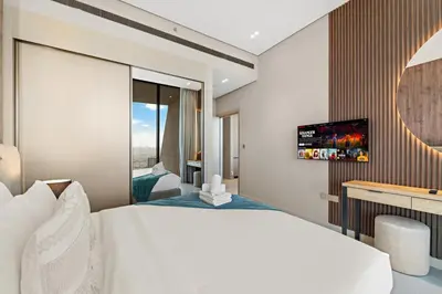 a hotel room with a large bed and a television at Luxe 1BR in JVC with Private Jacuzzi & Pool Access in Dubai