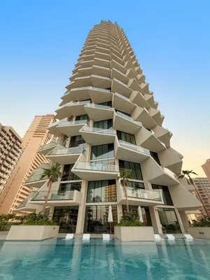 a tall building with a swimming pool in front of it at Luxe 1BR in JVC with Private Jacuzzi & Pool Access in Dubai