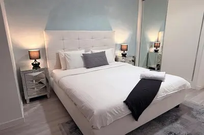 a bedroom with a large white bed with two lamps at Lovely beach life 1 bed apartment in Dubai Marina in Dubai