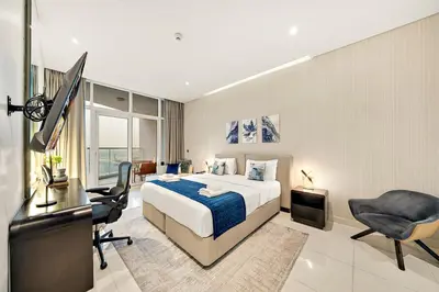 a bedroom with a bed and a desk and a television at Luxe 1BR with Balcony & Canal View in Dubai