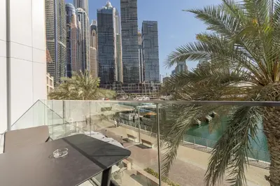 a balcony with palm trees and a view of a city at Luxury 2BR LIV Marina Dubai World-Class Amenities in Dubai