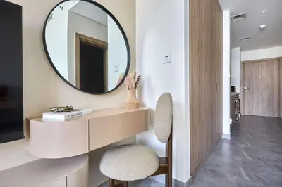 a bathroom with a mirror and a table and two chairs at Frank Porter - Peninsula One in Dubai