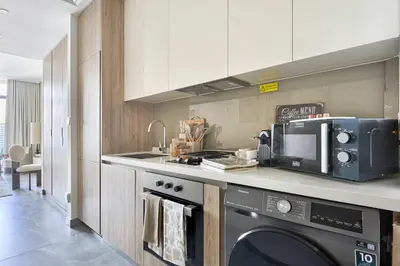 a kitchen with a microwave and a stove top oven at Frank Porter - Peninsula One in Dubai