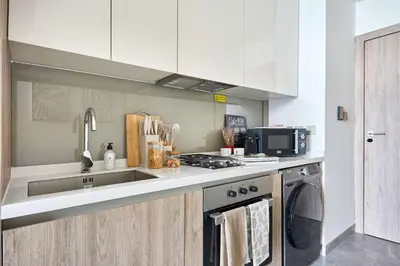 a kitchen with a sink and a stove at Frank Porter - Peninsula One in Dubai
