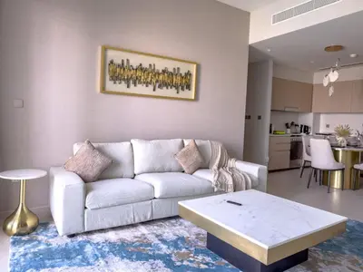 a living room with a couch and a table at GRANDE SIGNATURE RESIDENCES direct Burj Khalifa view and Private Fountain Show at high floor with DXB AIRPORT VIP Shuttle option in Dubai