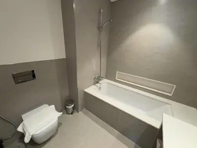 a bathroom with a white toilet and a bath tub at GRANDE SIGNATURE RESIDENCES direct Burj Khalifa view and Private Fountain Show at high floor with DXB AIRPORT VIP Shuttle option in Dubai