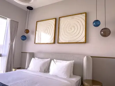a bedroom with two framed pictures above a bed at GRANDE SIGNATURE RESIDENCES direct Burj Khalifa view and Private Fountain Show at high floor with DXB AIRPORT VIP Shuttle option in Dubai