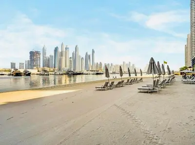a group of beach chairs with umbrellas on the beach at Luxury Sea View 1BR l Palace Beach Residence in Dubai